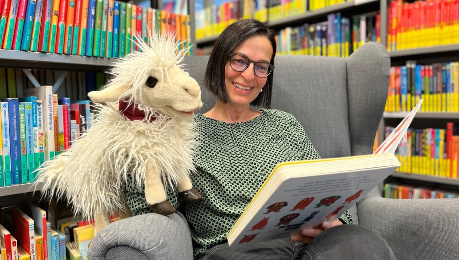 Vorlese-Heldin Anette und Schnaaf, das Leseschaf beim Vorlesen in der Stadtbücherei